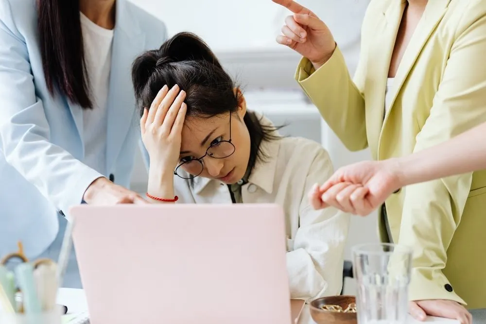 Profissional stressada com excesso de trabalho num escritório, representando a necessidade de automatização de tarefas empresariais